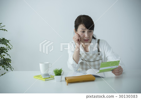 Middle housewife receiving shock when looking at passbook 30130383