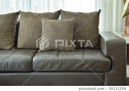 Brown pillows on brown leather sofa in living room Brown pillows on brown leather sofa in living room 30131209
