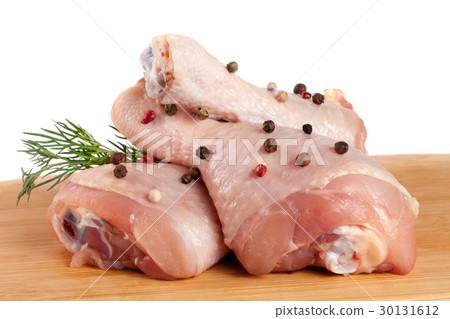 raw chicken drumsticks on a wooden cutting boardn 30131612