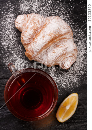croissant with a cup of tea on a black stone croissant with a cup of tea on a black stone 30133860