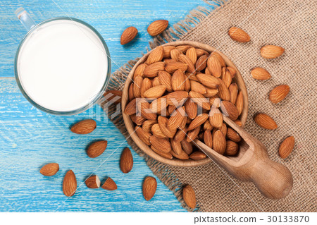 Almond milk in a glass and almonds in a bowl on Almond milk in a glass and almonds in a bowl on 30133870