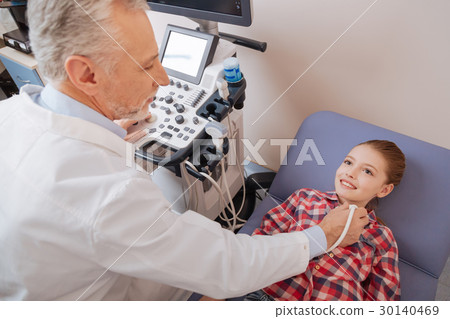 Delighted kid enjoying ultrasonic thyroid 30140469
