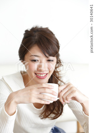 A woman holding a coffee cup A woman holding a coffee cup 30140641
