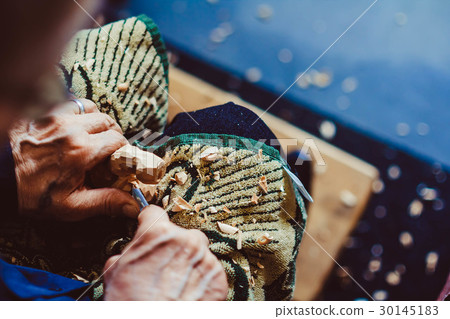 a craftsman carves wood 30145183