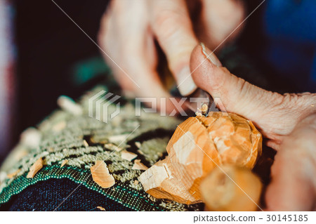 a craftsman carves wood 30145185