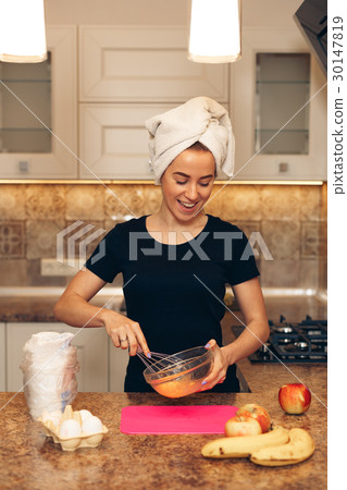 Beautiful young woman smiling while baking in Beautiful young woman smiling while baking in 30147819