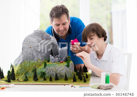 Father and son work on model building project 30148748