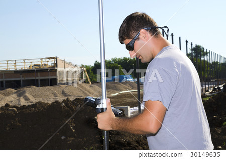 Geodesist working at a new village stadium Geodesist working at a new village stadium 30149635
