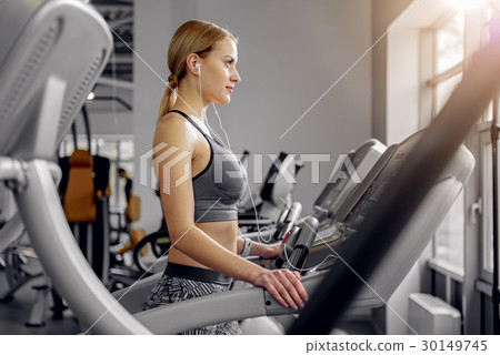 Calm woman hearing song on treadmill 30149745
