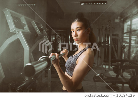 young Woman doing exercise with barbell 30154129