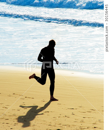 Man running on a beach 30156445