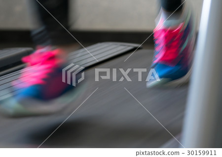 Woman running on treadmill 30159911