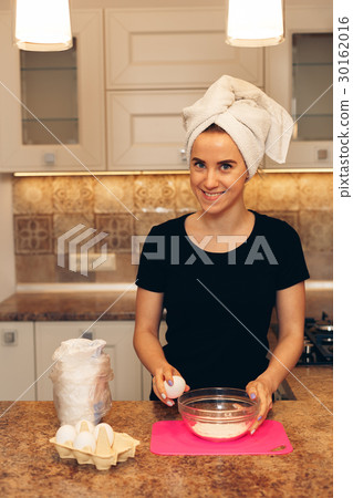 Woman breaks the eggs for the preparation omelet 30162016