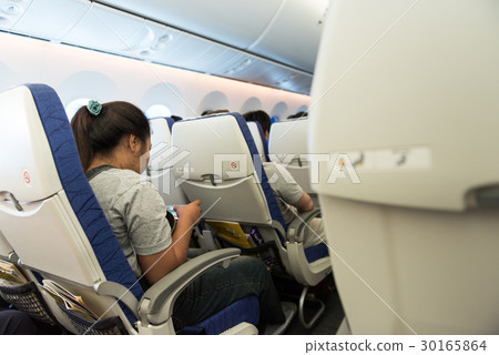 Asia lady passenger play games on mobile phone Asia lady passenger play games on mobile phone 30165864