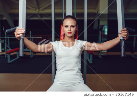 Beautiful girl doing exercises on the simulator in Beautiful girl doing exercises on the simulator in 30167149