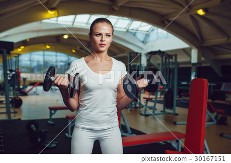 Beautiful girl doing exercises with dumbbells in 30167151