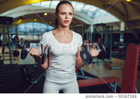 Beautiful girl doing exercises with dumbbells in 30167168