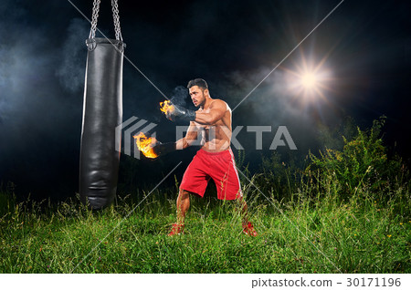 Professional boxer punching sandbag outdoors with 30171196