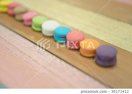 Multicolored macaroons on white wooden background 30171412