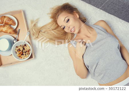 Young beautiful woman having breakfast in bed. Young beautiful woman having breakfast in bed. 30172122