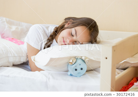Teenage girl sleeping on alarm clock Teenage girl sleeping on alarm clock 30172416