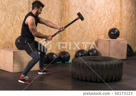 Sport Fitness Man Hitting Wheel Tire With Hammer Sport Fitness Man Hitting Wheel Tire With Hammer 30173123