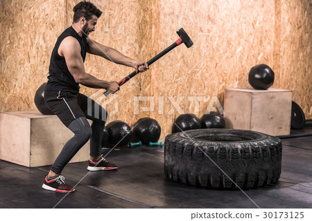 Sport Fitness Man Hitting Wheel Tire With Hammer 30173125