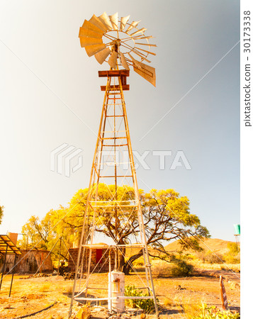Old windmill water pump in dry landscape. Metallic 30173338