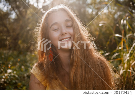Happy girl posing in front of high grass  30173434