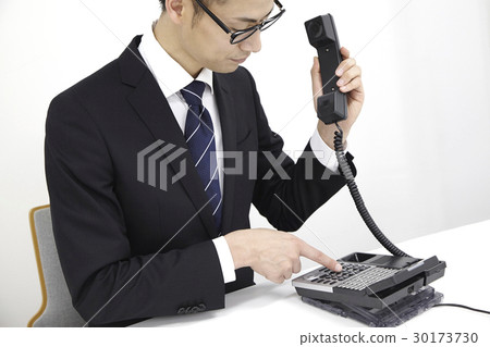 Male office worker who supports telephone with business phone Male office worker who supports telephone with business phone 30173730