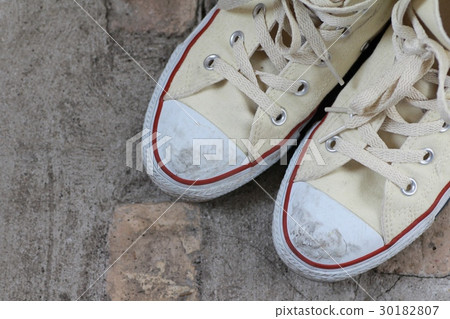 The toes of worn high-top sneakers 30182807