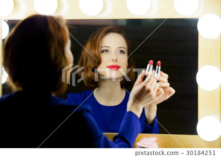 portrait of beautiful young woman holding lipstick portrait of beautiful young woman holding lipstick 30184251