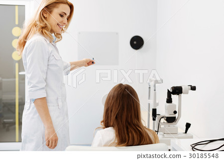 Lovely friendly ophthalmologist conducting an Lovely friendly ophthalmologist conducting an 30185548