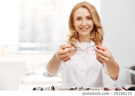 Friendly smiling lady giving out glasses 30186133