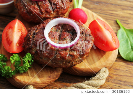 Homemade beef burger with onion on cutting board Homemade beef burger with onion on cutting board 30186193