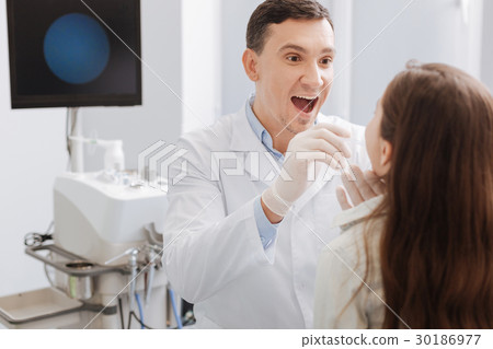 Delighted ENT doctor examining sore throat 30186977