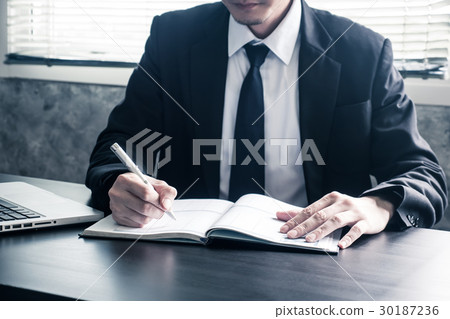 Businessman writing some data in notebook  30187236