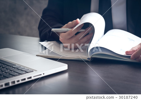 Businessman checking documents on the office desk. Businessman checking documents on the office desk. 30187240