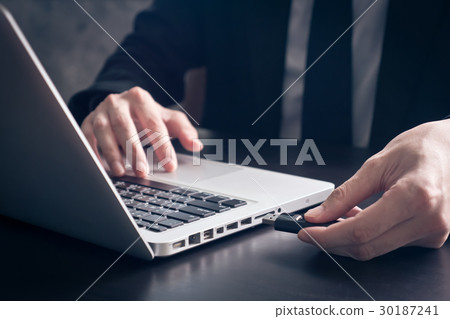 Businessman using flash drive connect to laptop Businessman using flash drive connect to laptop 30187241