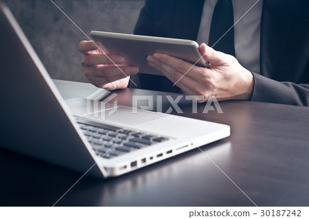 Businessman using tablet on the office desk. Businessman using tablet on the office desk. 30187242