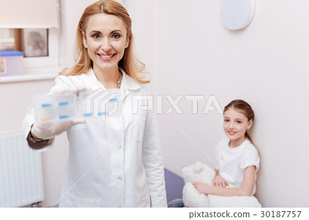 Positive delighted pediatrician demonstrating box Positive delighted pediatrician demonstrating box 30187757