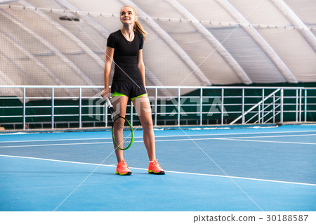 The young girl in a closed tennis court with ball The young girl in a closed tennis court with ball 30188587