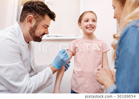 Delighted male doctor doing an injection 30189054