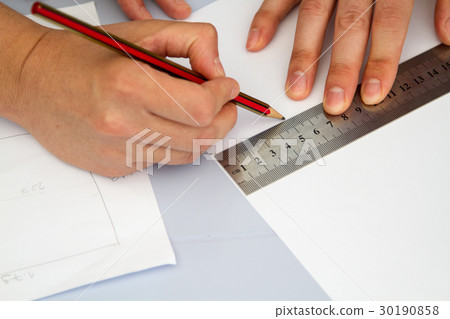 hands holding ruller and pencil over sheme  30190858
