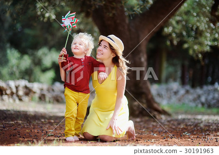 Female farmer and her little helper working in olive grove in Italy Female farmer and her little helper working in olive grove in Italy 30191963