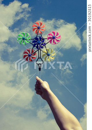 hand hold pinwheel on blue sky background hand hold pinwheel on blue sky background 30192815