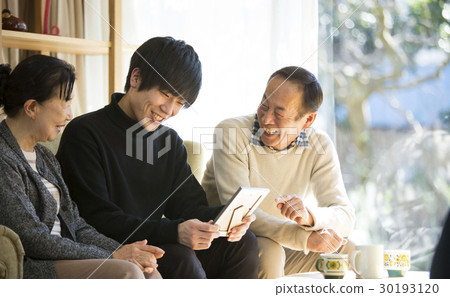Grandparents and grandchildren looking at photos 30193120