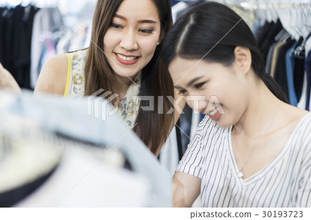 Young girls look very delighted while choosing clothes Young girls look very delighted while choosing clothes 30193723