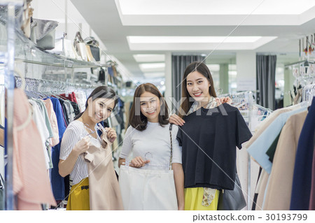 A group of women are trying clothes in the store. 30193799