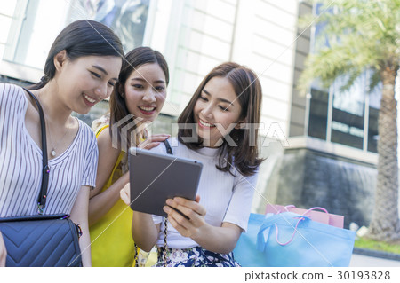 Three ladies are using app on the tablet. 30193828